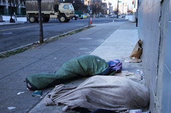 caption: Homeless individuals sleep near a National Guard truck ahead of the inauguration of U.S. President-elect Joe Biden on Jan. 20, 2021, in Washington, D.C.