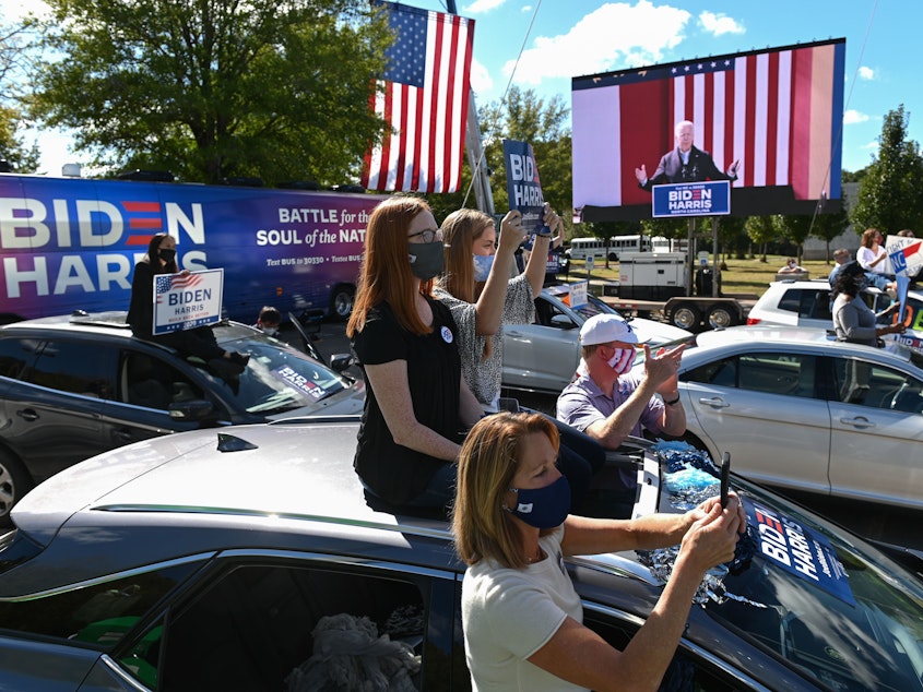 caption: Supporters of Democratic presidential nominee Joe Biden sit on top of their vehicles as they listen to him speak at Riverside High School in Durham, N.C., on Sunday afternoon.