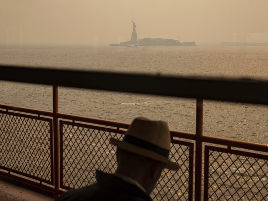 caption: The Statue of Liberty is seen June 7 through a haze-filled sky from the Staten Island Ferry in New York. The smoke from Canadian wildfires that drifted into the U.S. led to a spike in people with asthma visiting emergency rooms — particularly in the New York area.