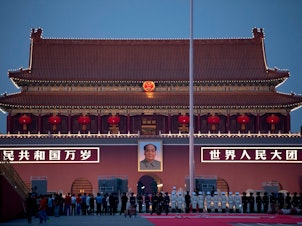 caption: Chinese honor guards stand in formation during the lowering of the national flag in front of Tiananmen Gate in Beijing on Monday, one day before the 70th anniversary of the founding of the People's Republic of China.