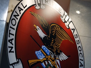 caption: The logo of the National Rifle Association is seen at an outdoor sports trade show in 2017.