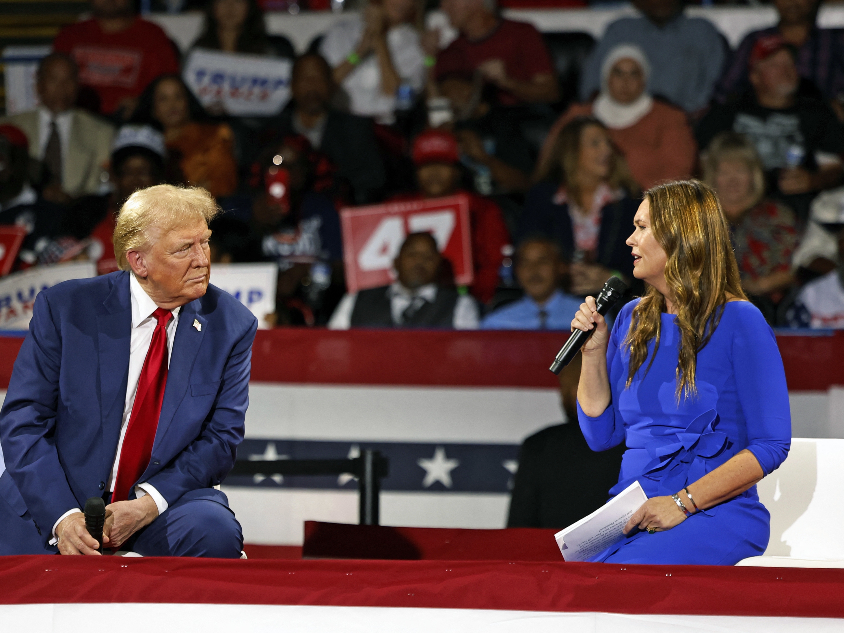 caption: Former President Trump attends a town hall meeting moderated by Arkansas Gov. Sarah Huckabee Sanders at the Dort Financial Center in Flint, Mich., on Tues.