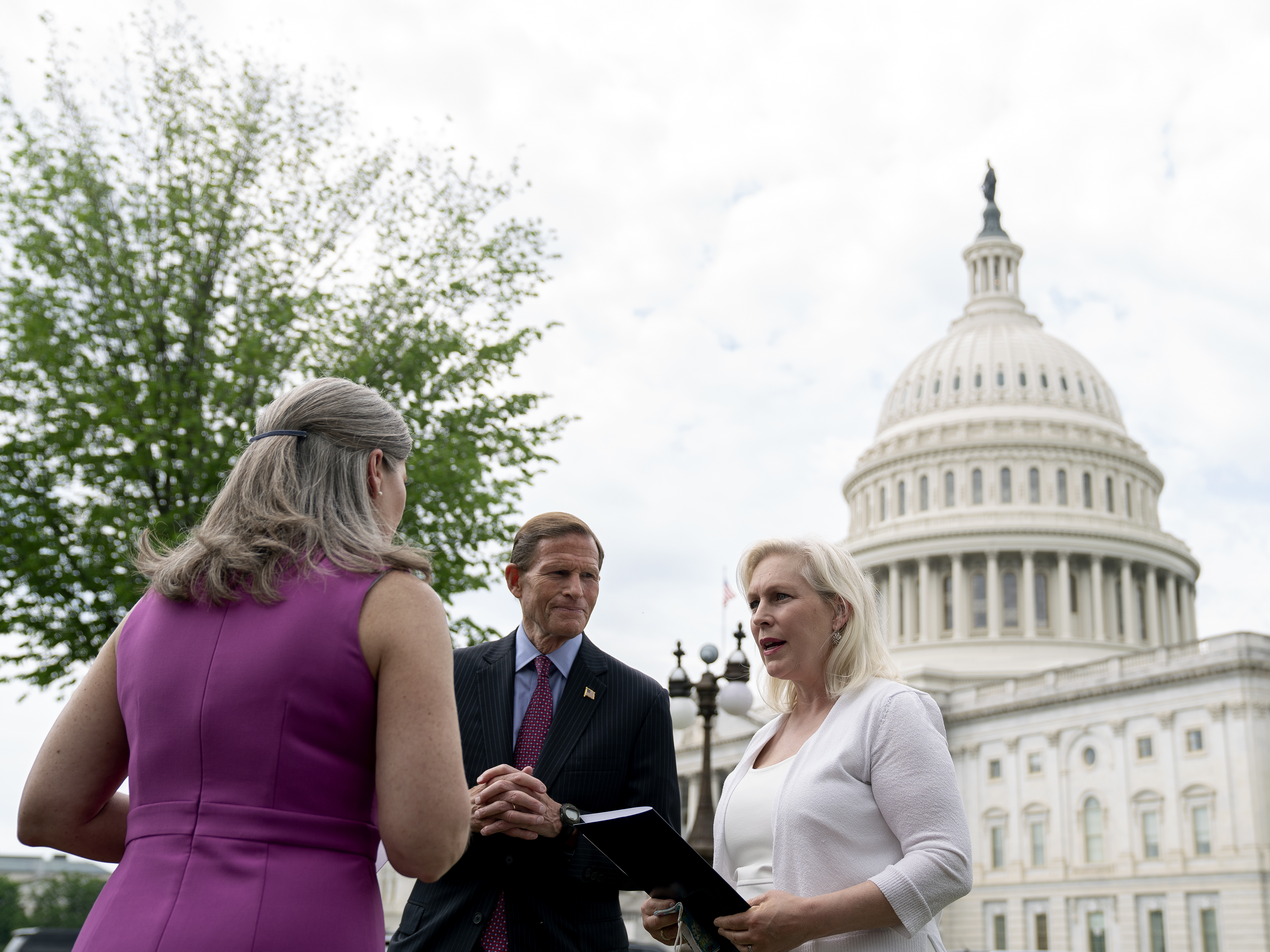 caption: Sen. Kirsten Gillibrand, D-N.Y., (right), speaks to Sen. Richard Blumenthal, D-Conn., and Sen. Joni Ernst, R-Iowa, following an April 29 news conference on the Military Justice Improvement and Increasing Prevention Act.
