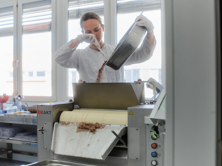 caption: An employee at the testing lab of Planet A Foods tests and processes ChoViva.