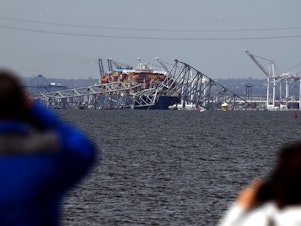caption: Francis Scott Key Bridge collapsed after being hit by the Dali container vessel, as seen from Riviera Beach, Md., on Tuesday.