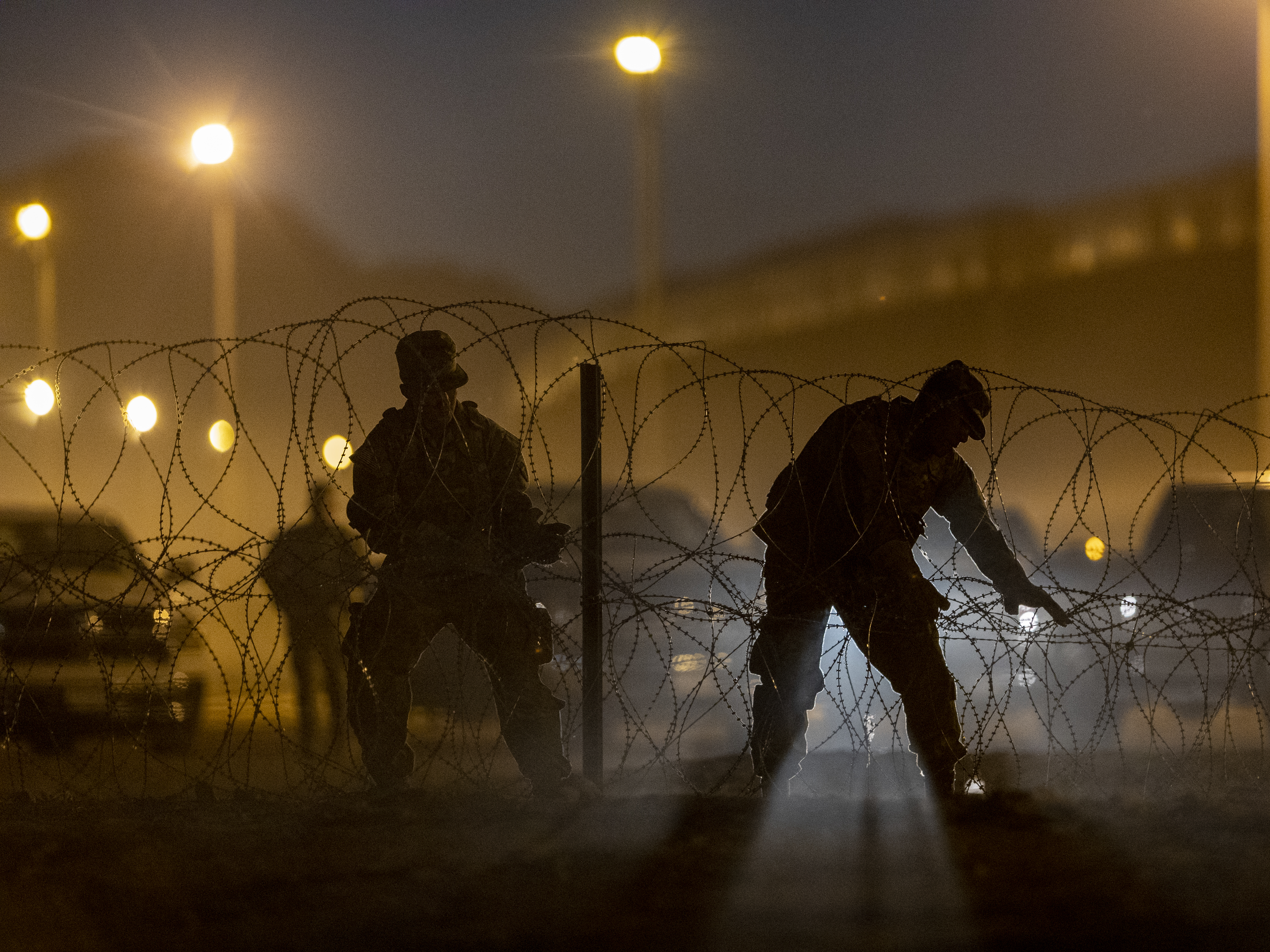 caption: Texas National Guard troops set up razor wire in El Paso, Texas. Officials are anticipating a wave of immigrants on Thursday night, with the end of the U.S. government's COVID-era Title 42 policy.