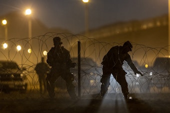 caption: Texas National Guard troops set up razor wire in El Paso, Texas. Officials are anticipating a wave of immigrants on Thursday night, with the end of the U.S. government's COVID-era Title 42 policy.