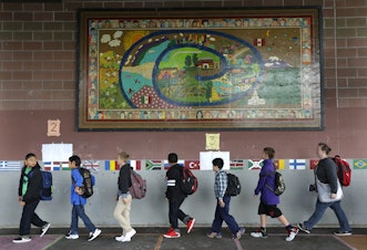caption: Students walk past a mural at Concord International School, Thursday, Sept. 17, 2015, in Seattle.