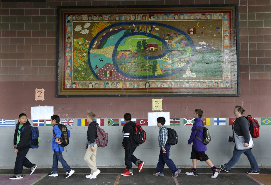 caption: Students walk past a mural at Concord International School, Thursday, Sept. 17, 2015, in Seattle.