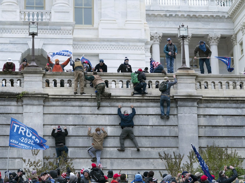caption: Trump supporters climb the west wall of the U.S. Capitol on Jan. 6, 2021. A new survey finds 1 in 10 Americans say violent protests are justified.