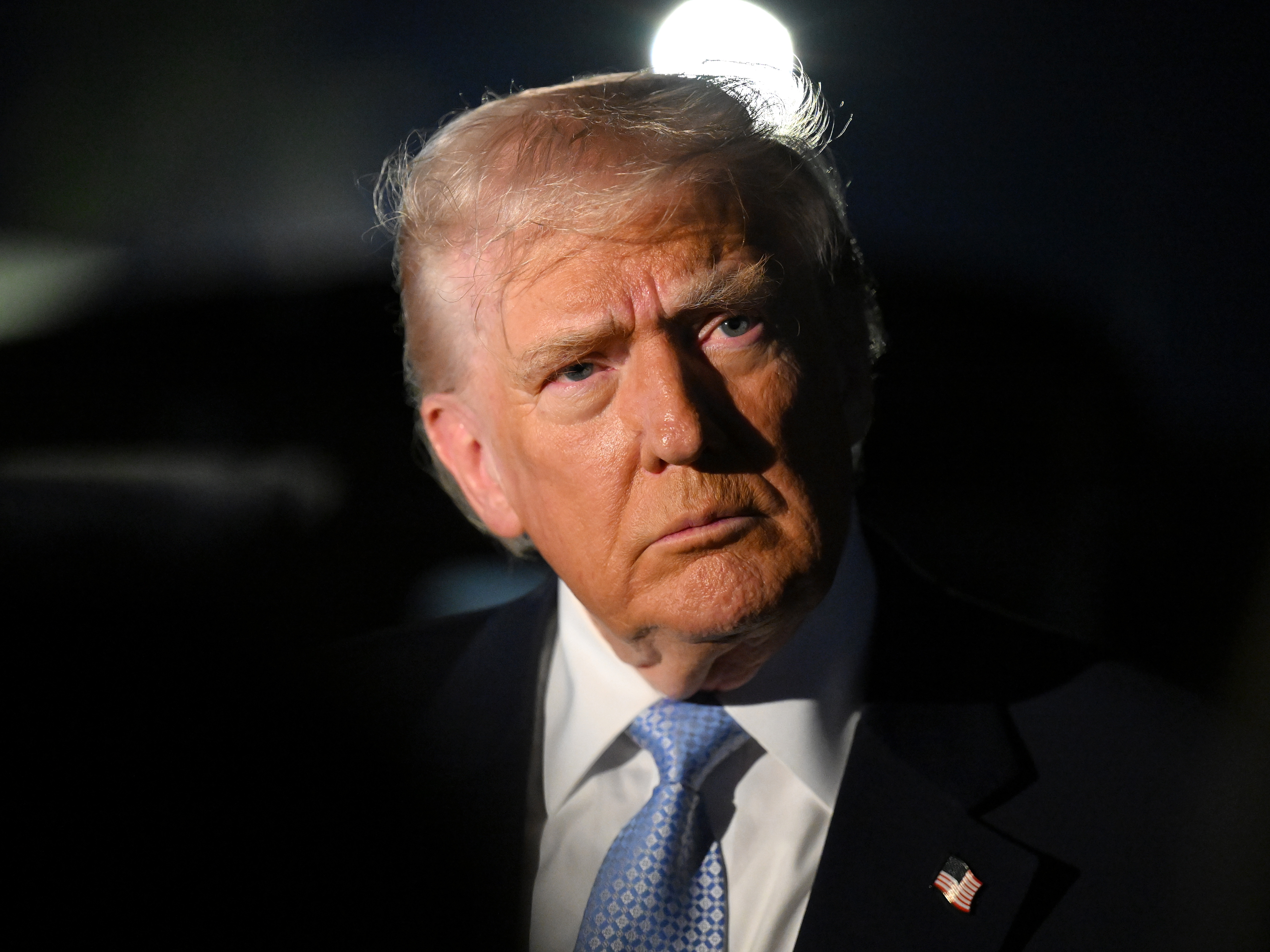 caption: U.S. President Donald Trump speaks to reporters before boarding Air Force One on November 16, 2025 at Palm Beach International Airport in West Palm Beach, Florida.