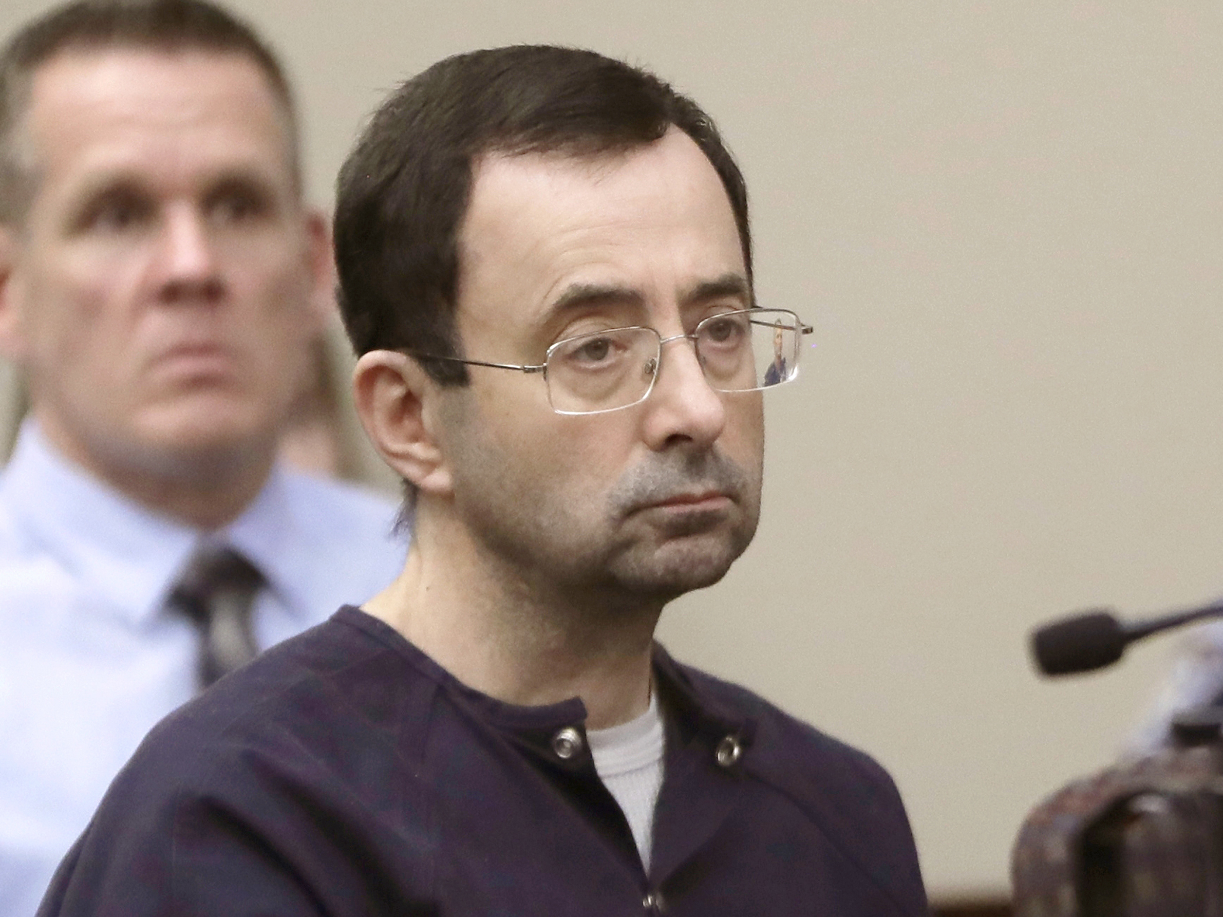 caption: Larry Nassar, a former doctor for USA Gymnastics and member of Michigan State's sports medicine staff, sits in court during his 2018 sentencing hearing in Lansing, Mich.