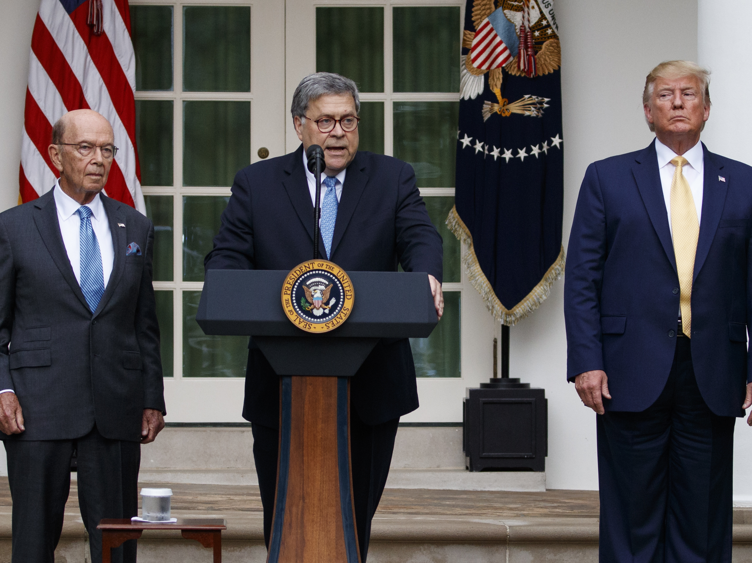 caption: Attorney General William Barr speaks as he stands with President Donald Trump and Commerce Secretary Wilbur Ross during an event about the census in the Rose Garden at the White House earlier this month.