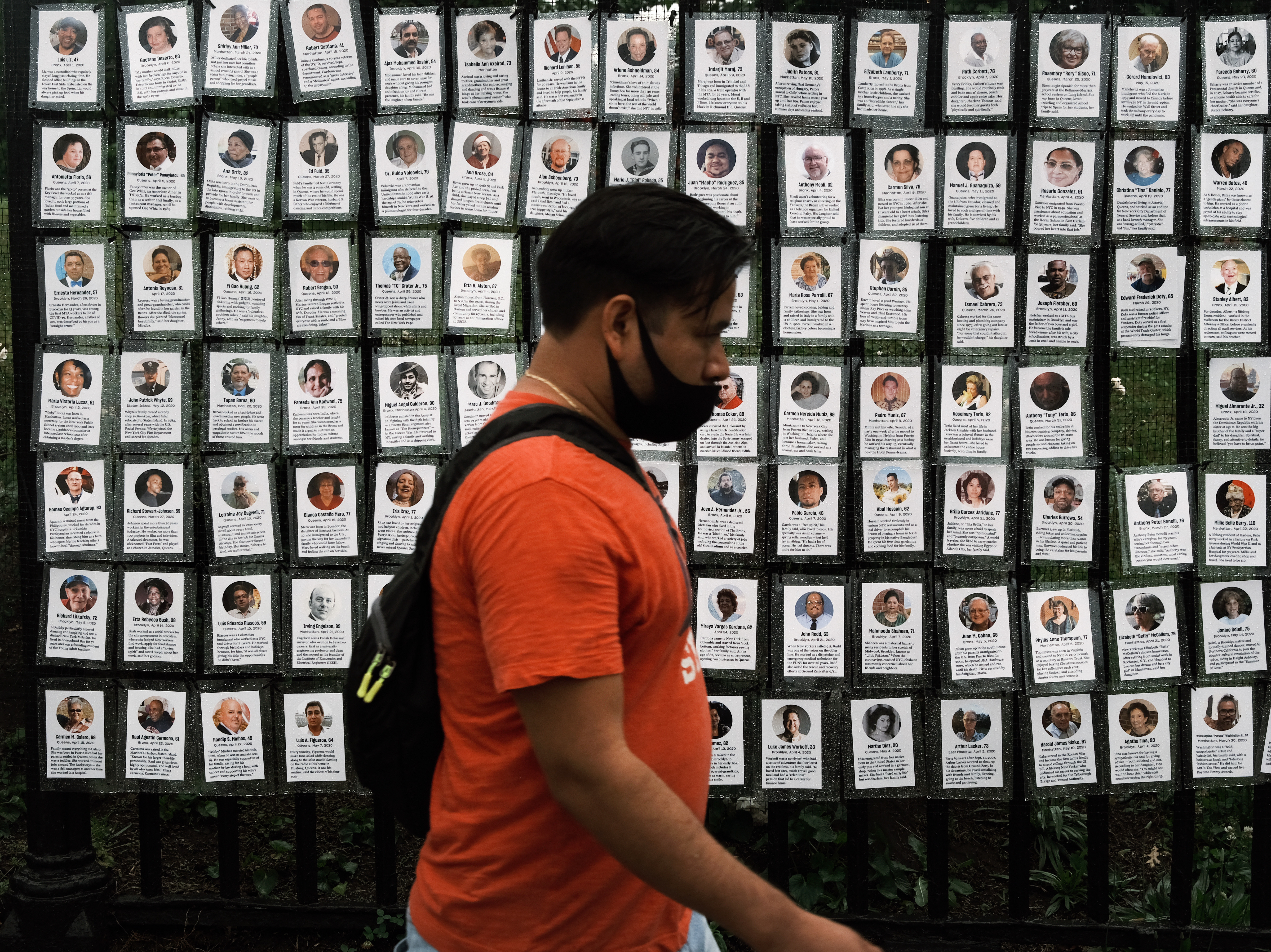 caption: Memorials hang from the front gate of Greenwood Cemetery in New York City during an event organized by Naming the Lost Memorials to remember and celebrate those who died during the COVID-19 pandemic.