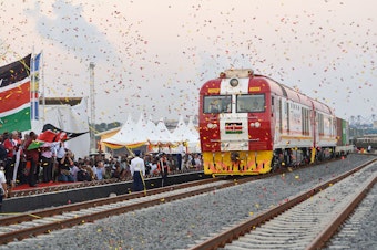 caption: People cheer and throw confetti after Kenyan President Uhuru Kenyatta flags off a cargo train for its inaugural journey to Nairobi last year at the port of the coastal town of Mombasa.
