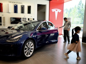 caption: A Tesla car is on display at a showroom in Beijing on May 10. Tesla's stock has soared from $430 a share at the start of 2020 to nearly $1,600 at Wednesday's close.