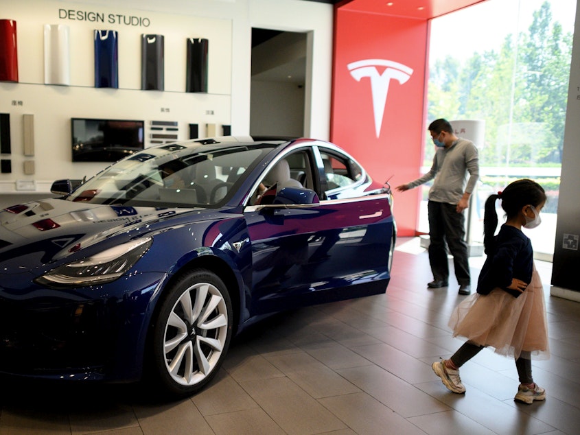 caption: A Tesla car is on display at a showroom in Beijing on May 10. Tesla's stock has soared from $430 a share at the start of 2020 to nearly $1,600 at Wednesday's close.