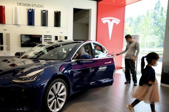 caption: A Tesla car is on display at a showroom in Beijing on May 10. Tesla's stock has soared from $430 a share at the start of 2020 to nearly $1,600 at Wednesday's close.