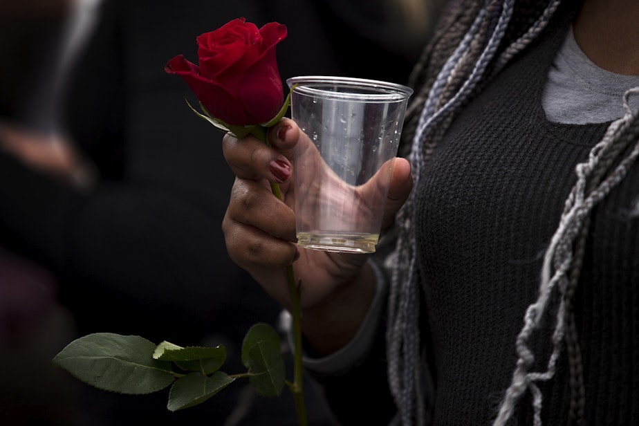 caption: Christina Shook holds a rose while drinking champagne during an impromptu celebration after Joe Biden was officially named the president elect on Saturday, November 7, 2020, at the intersection of 10th Avenue and East Pine Street in Seattle.