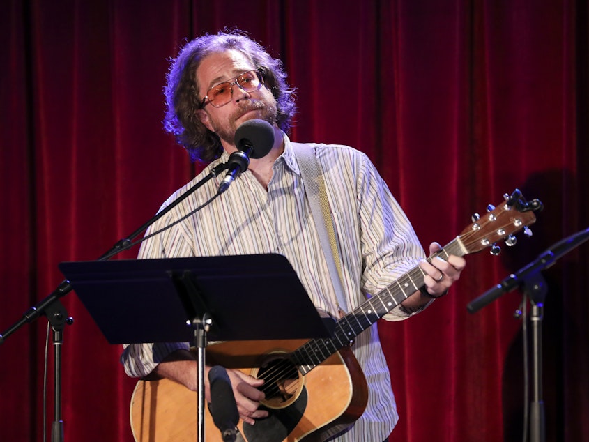 caption: Ask Me Another's house musician Jonathan Coulton leads a music parody game at the Bell House in Brooklyn, New York.