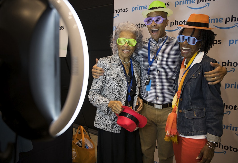 caption: Joseph Jones, an Amazon employee on the marketing team for Amazon channels, takes pictures with his mother, Cathy Jones, right, and his grandmother, Hattie Perry, left, during Amazon's bring your parents to work day on Friday, September 15, 2017.