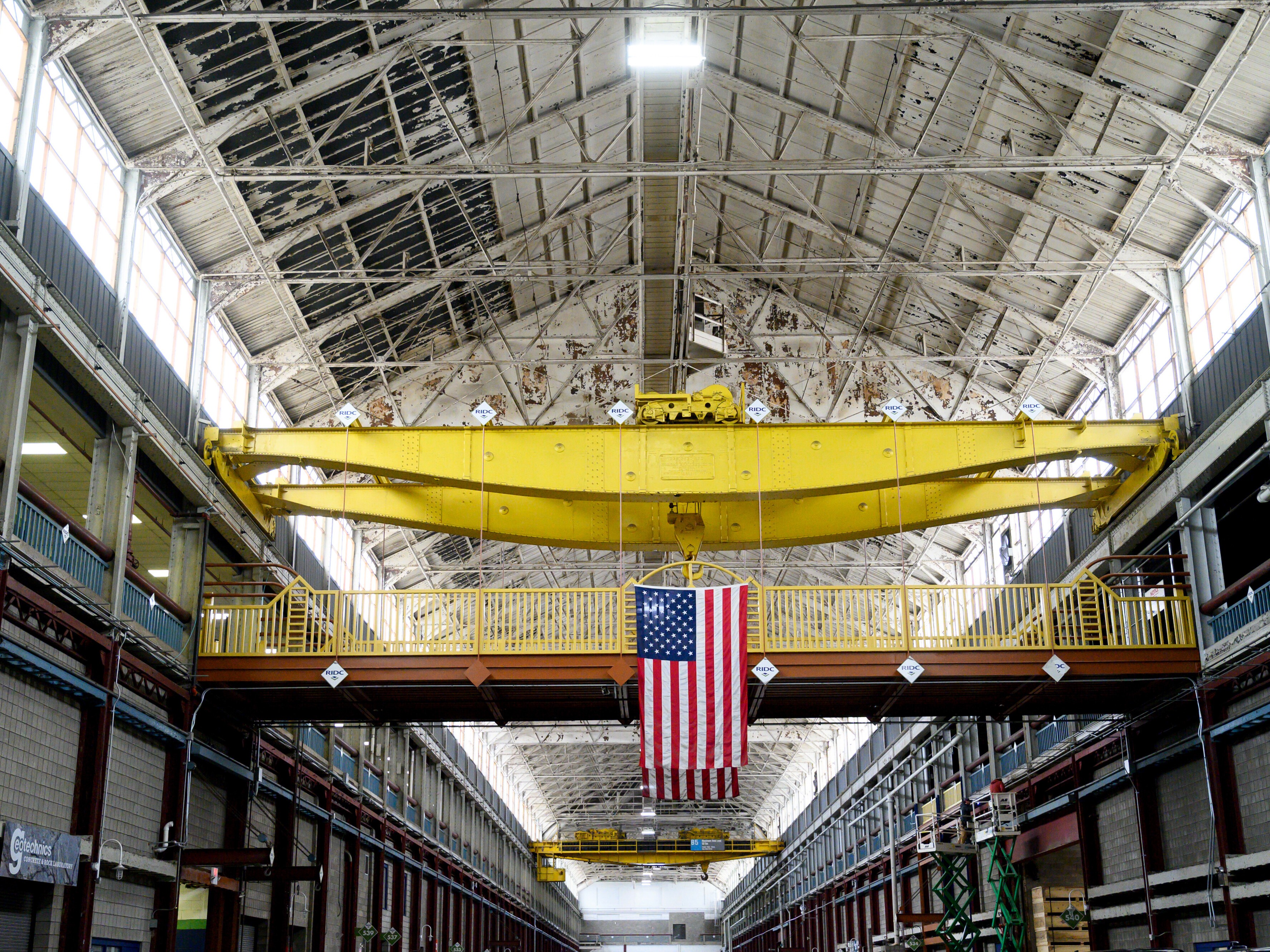 caption: An American flag hangs inside the former Westinghouse plant in Turtle Creek, Pa., which now houses several businesses, including the Eos Energy Enterprises Inc. manufacturing facility.
