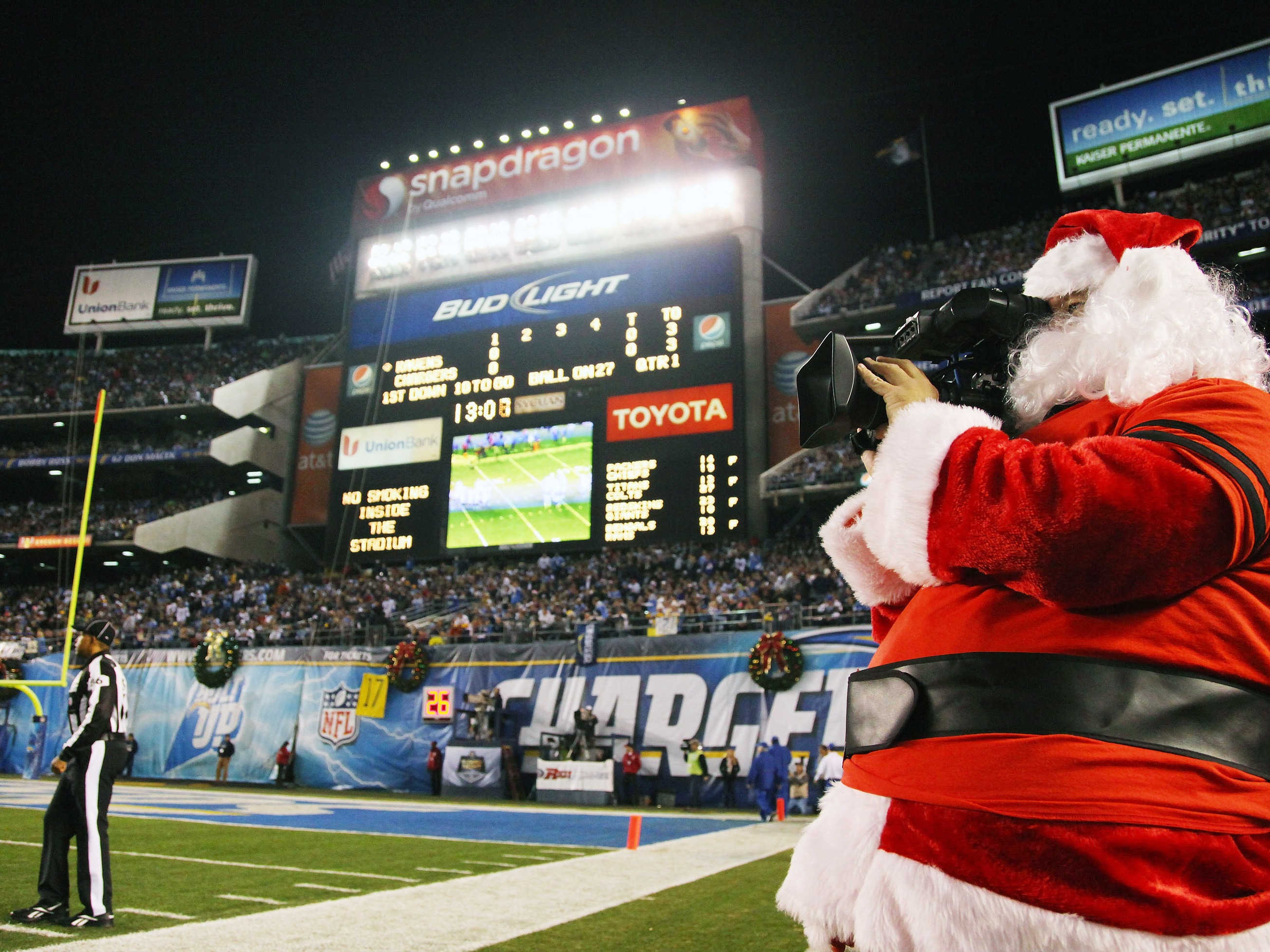 caption: A television camera operator is dressed as Santa Claus during the Baltimore Ravens and San Diego Chargers game on Dec. 18, 2011, at Qualcomm Stadium in San Diego.