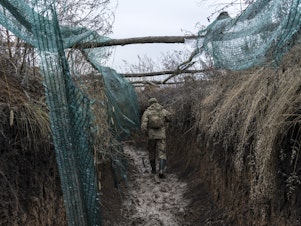 caption: A Ukrainian soldier walks in a trench on the front line in Zolote, Ukraine, earlier this month. A buildup of Russian troops along the border with Ukraine has heightened worries that Russia intends to invade.