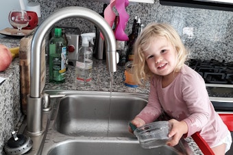 caption: Our correspondent Michaeleen Doucleff's daughter, Rosy, at age 2, as she does dishes voluntarily. Getting her involved in chores did lead to the kitchen being flooded and dishes being broken, Doucleff reports. But Rosy is still eager to help.
