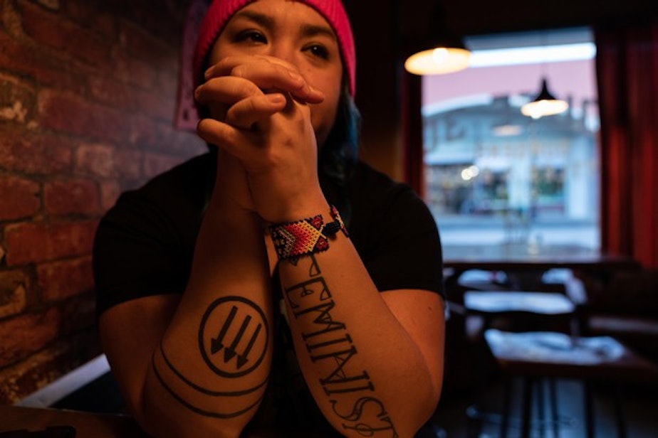 caption: <p>Rosie Strange sits in a restaurant after the Women&rsquo;s March on Jan. 19, 2019 in The Dalles, Ore. Her left arm says "FEMINIST" and her right arm has an anti-fascist symbol on it.</p>