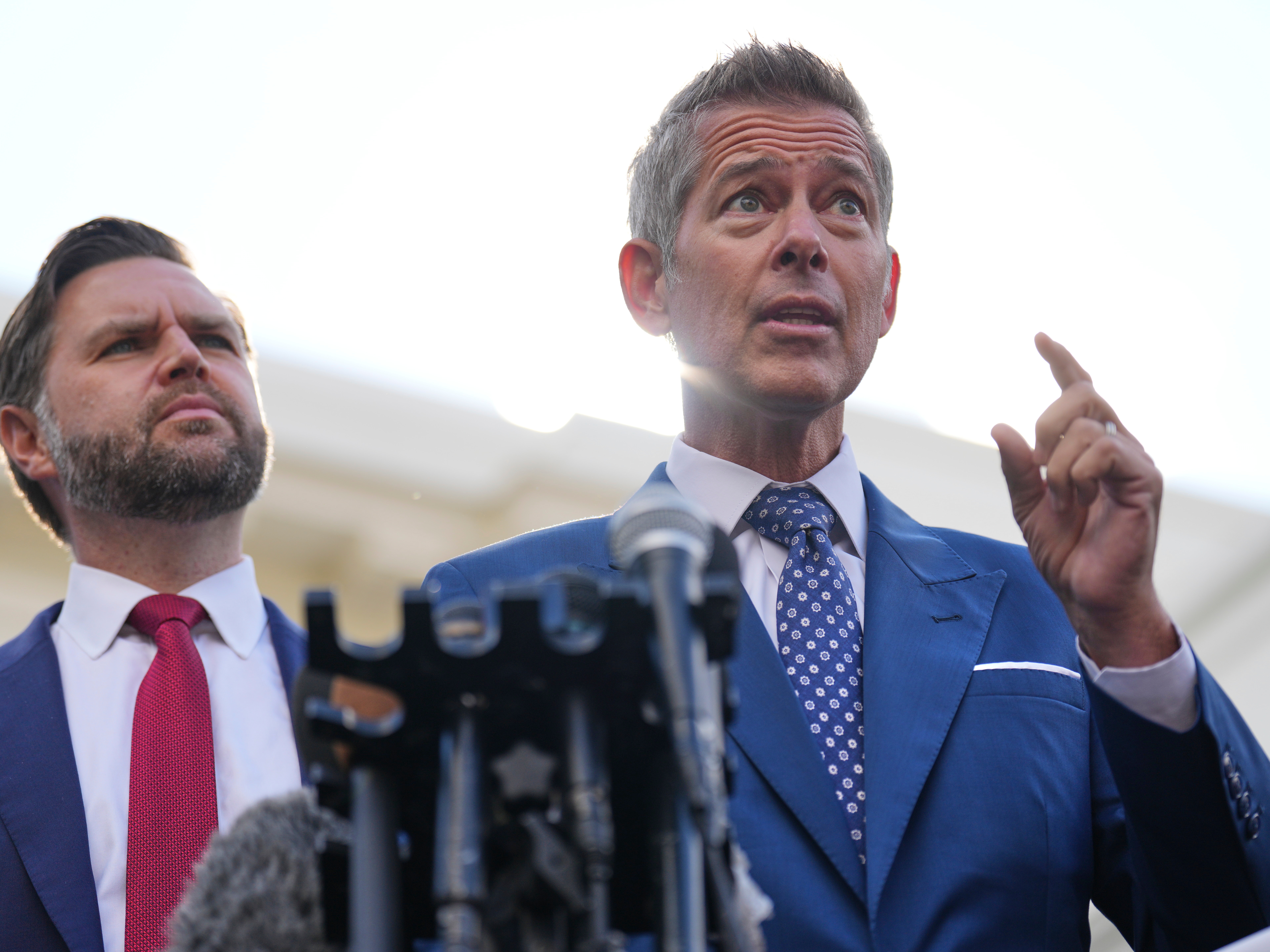 caption: U.S. Transportation Secretary Sean Duffy speaks next to Vice President JD Vance outside the White House in Washington, Oct. 30, 2025.