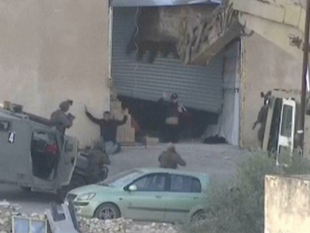 caption: This image taken from video by Palestine TV shows two Palestinian men kneeling on the ground to Israeli forces shortly before they were shot dead during a military operation in Jenin, West Bank, on Thursday, Nov. 27, 2025.