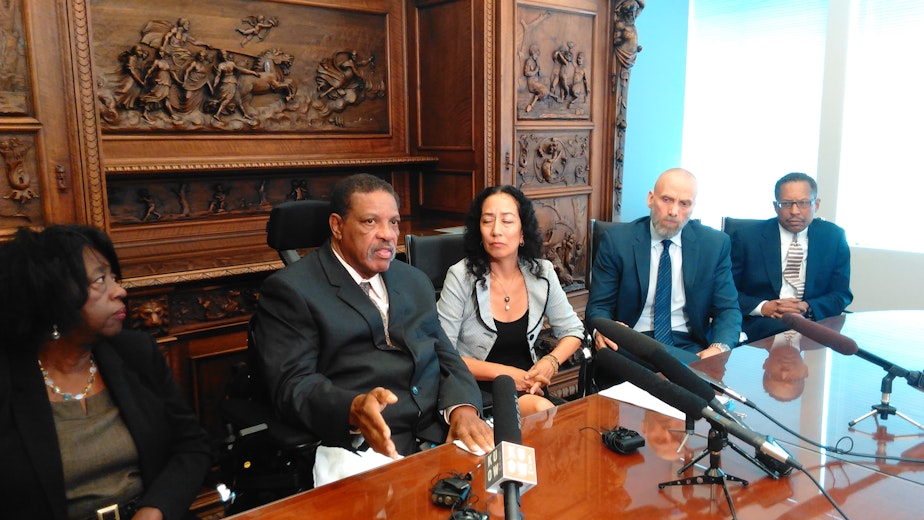 caption: Charleena Lyles' father, Charles Lyles, with his wife and attorneys