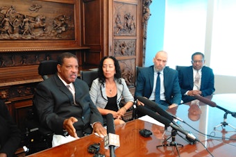 caption: Charleena Lyles' father, Charles Lyles, with his wife and attorneys