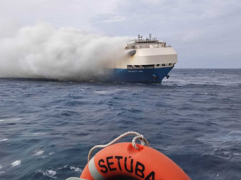caption: In this undated photo provided by the Portuguese Navy on Feb. 18, 2022, smoke billows from the burning Felicity Ace car transport ship as seen from the Portuguese Navy vessel NPR Setubal southeast of the mid-Atlantic Portuguese Azores Islands. The large cargo vessel carrying cars from Germany to the United States sank in the mid-Atlantic 13 days after a fire broke out on board.