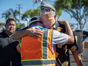caption: Maui County Mayor Richard Bissen Jr. visits a distribution center at Lahaina Crossing. A deadly wildfire destroyed the city of Lahaina, Maui.
