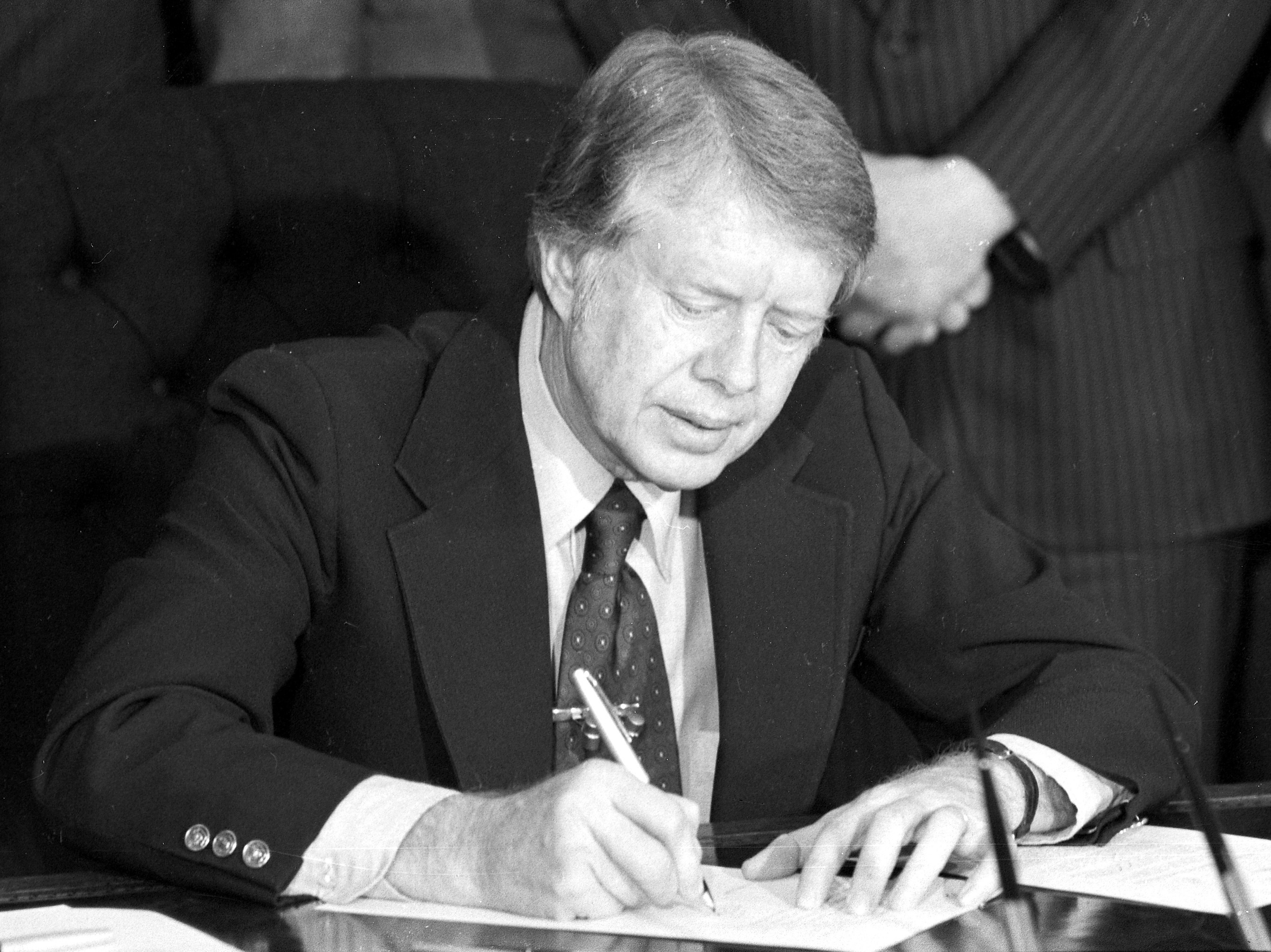 caption: President Jimmy Carter signs emergency natural gas legislation in the Oval Office of the White House in Washington, D.C., on Feb. 2, 1977. An oil crisis contributed to a period of double-digit inflation in the 1970s.