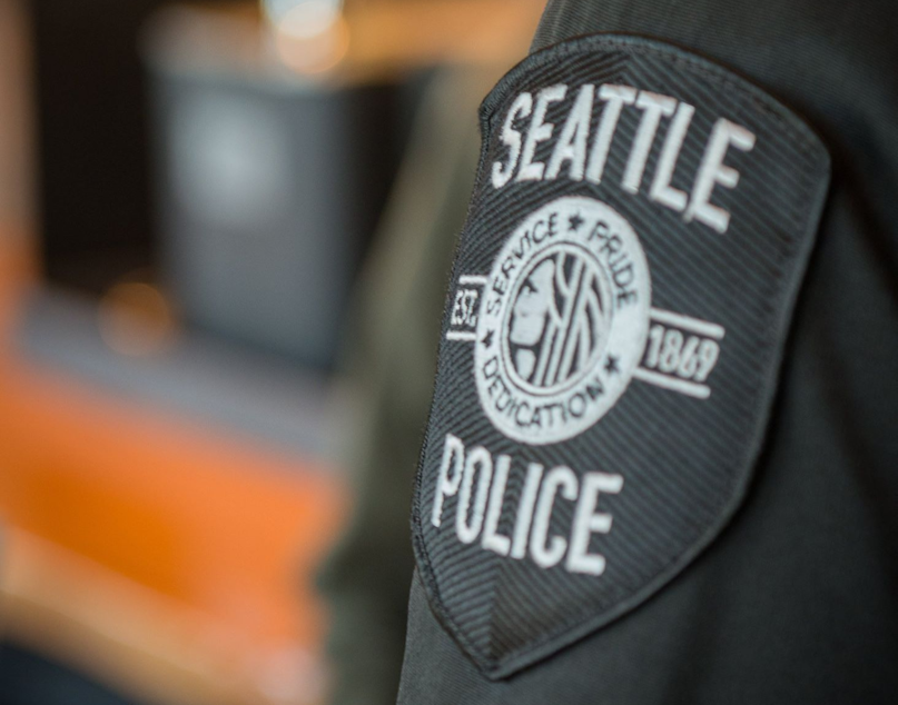 caption: A badge on the arm of a Seattle police officer. 