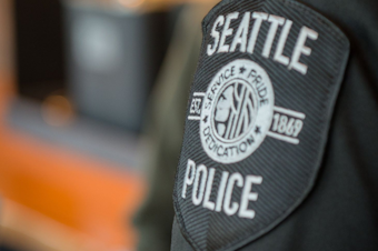 caption: A badge on the arm of a Seattle police officer. 