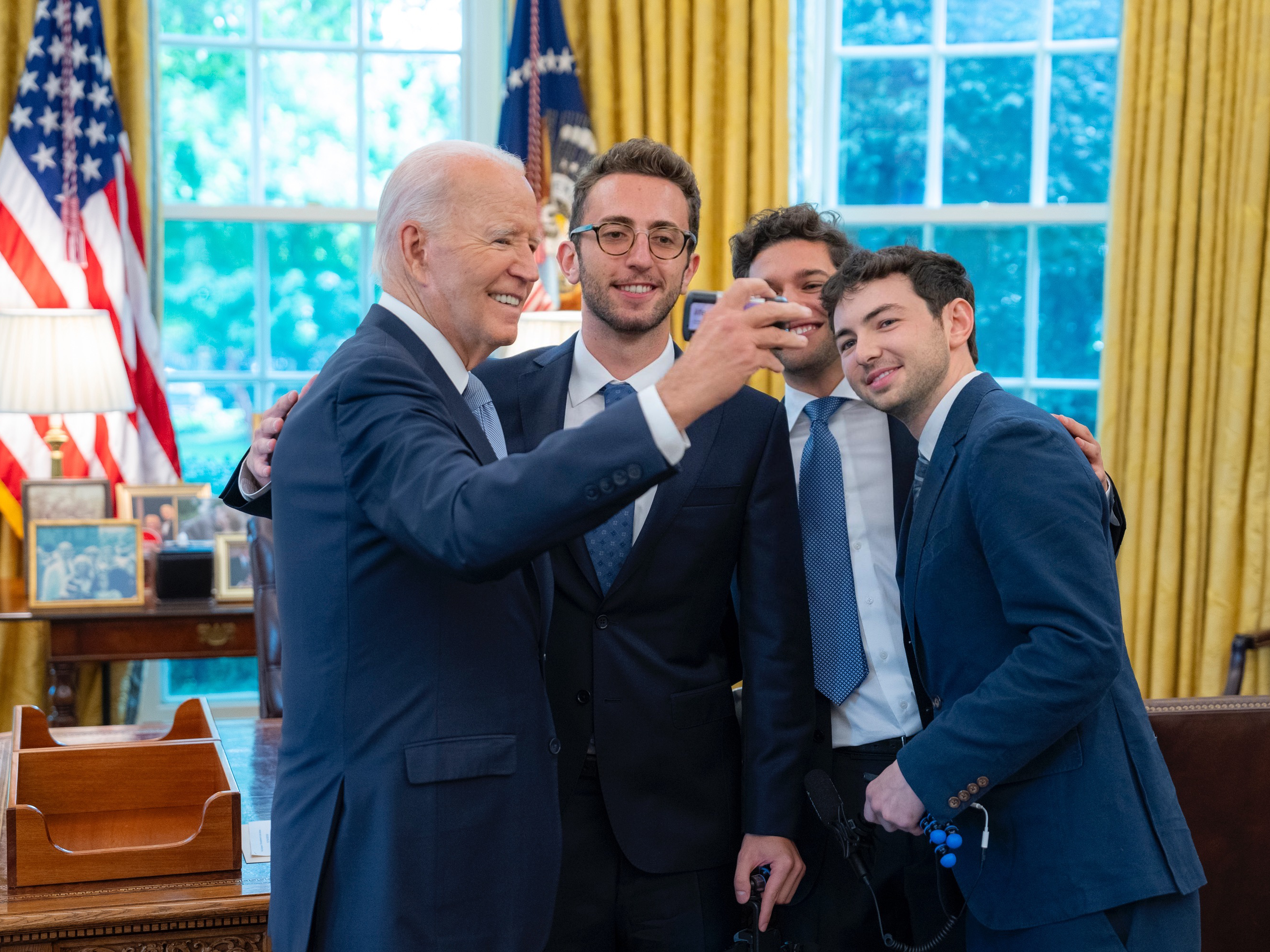 caption: Christian Baiocco, Griffin Katz and Grant Weintrob pose for a film photo with President Joseph Biden.