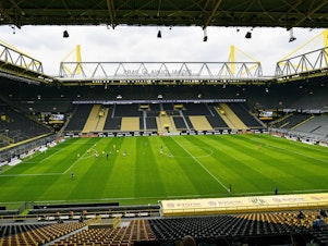 caption: Empty seats are seen in the Signal Iduna Park without spectators during the German Bundesliga soccer match between Borussia Dortmund and Schalke 04 in Dortmund, Germany on Saturday
