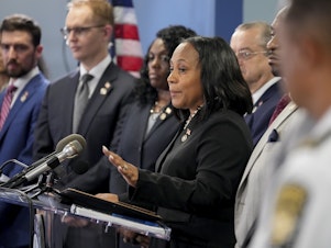 caption: Fulton County District Attorney Fani Willis, center, during a news conference on August 14.