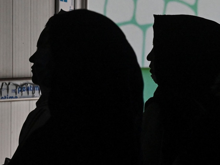 caption: Afghan women gather to protest claims of human rights violations of women by the Taliban regime.