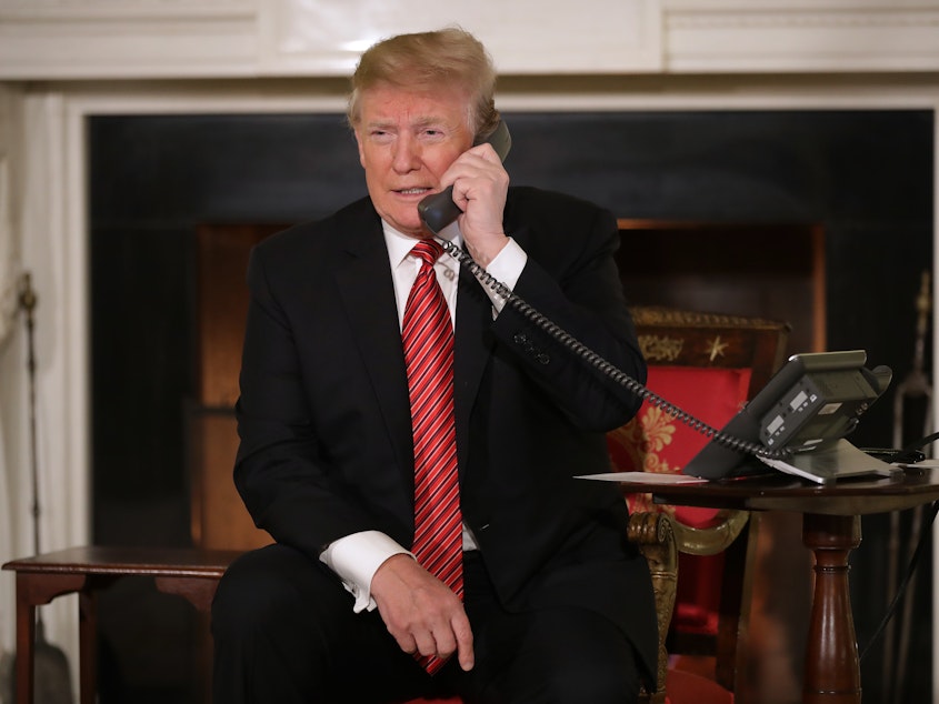 caption: President Trump takes phone calls from children as he participates in NORAD's Santa tracker on Christmas Eve at the White House. He caused a stir by asking a 7-year-old caller if she still believed in Santa Claus.