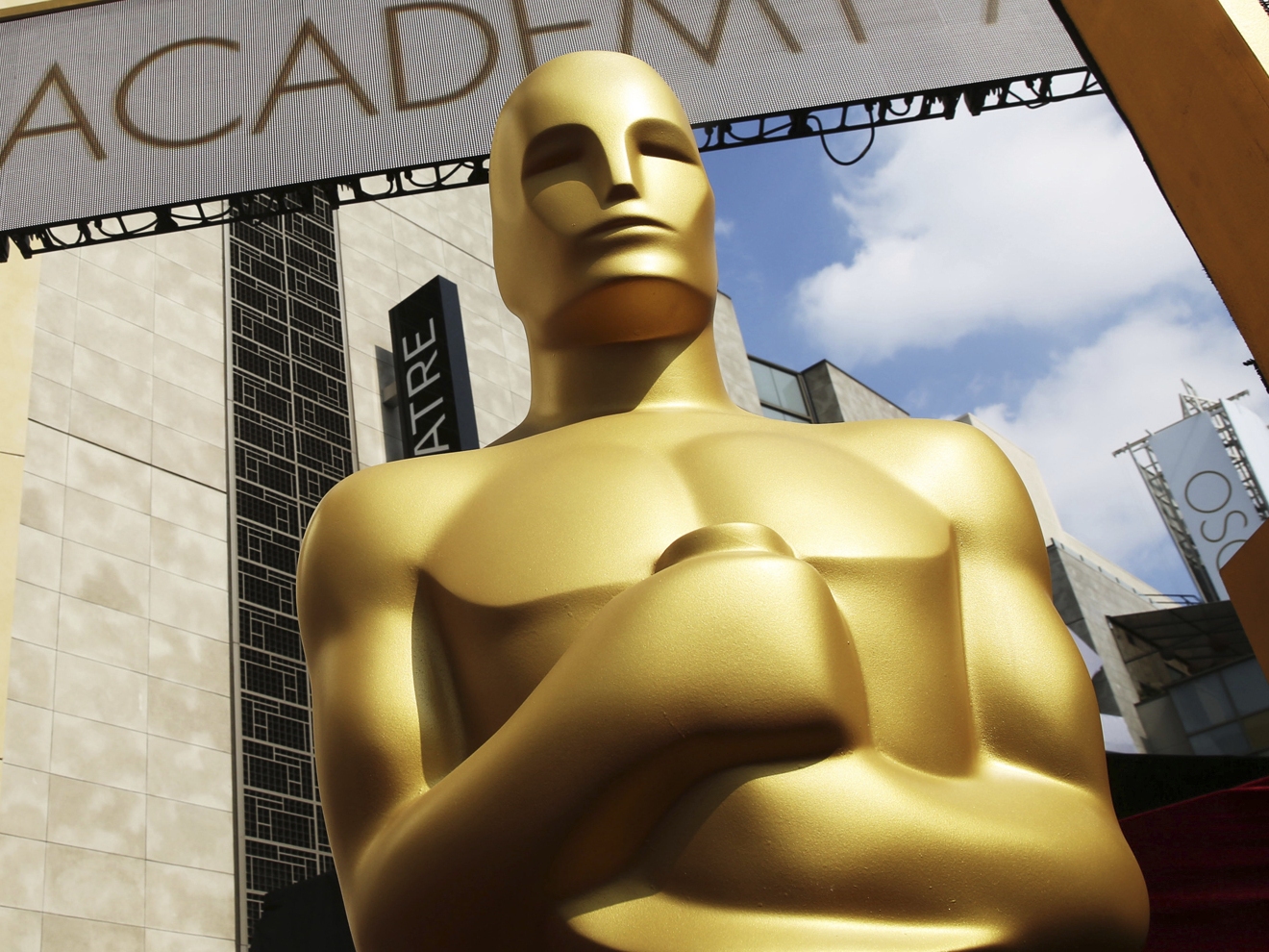 caption: An Oscar statue appears outside the Dolby Theatre ahead of the 2015 ceremony. But who is he really?