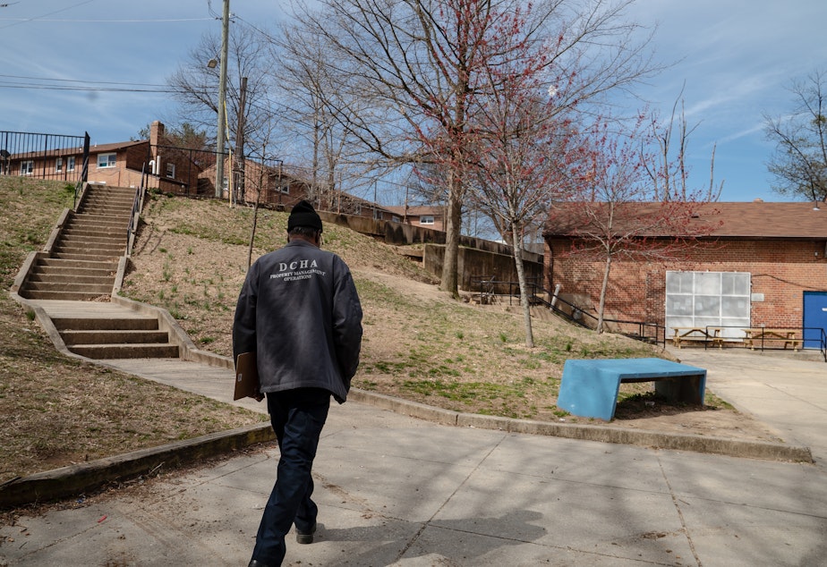 caption: An employee of the District of Columbia Housing Authority walks on the grounds of a public housing complex called Richardson Dwellings in Northeast Washington, D.C. The Trump administration wants to eliminate the federal fund now used to repair public housing in favor of attracting more private investment to repair and replace it.