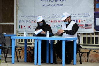 caption: United Nations High Commissioner for Refugees workers prepare to distribute non-food items to women at UNHCR office in Kandahar on March 8, 2022. The Taliban has demanded that Afghan women no longer work for the UN or NGOs.