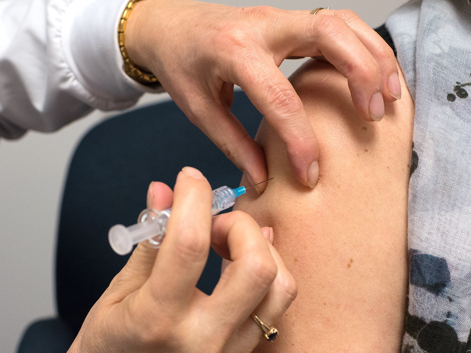 caption: A patient gets a flu vaccine. 
