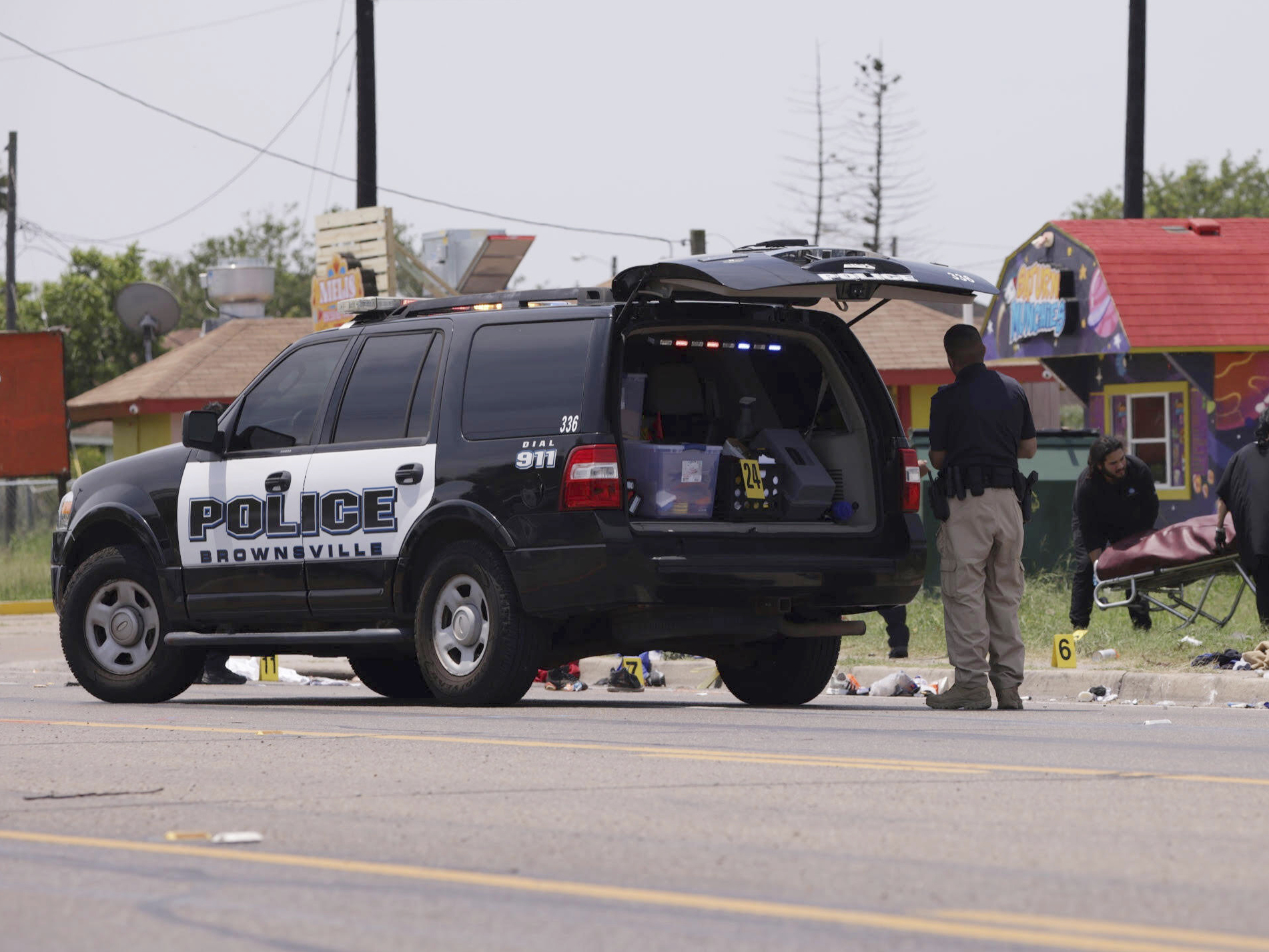caption: Emergency personnel respond to a fatal collision in Brownsville, Texas, on Sunday. Several people were killed after they were struck by a vehicle while waiting at a bus stop near Ozanam Center, a migrant and homeless shelter.
