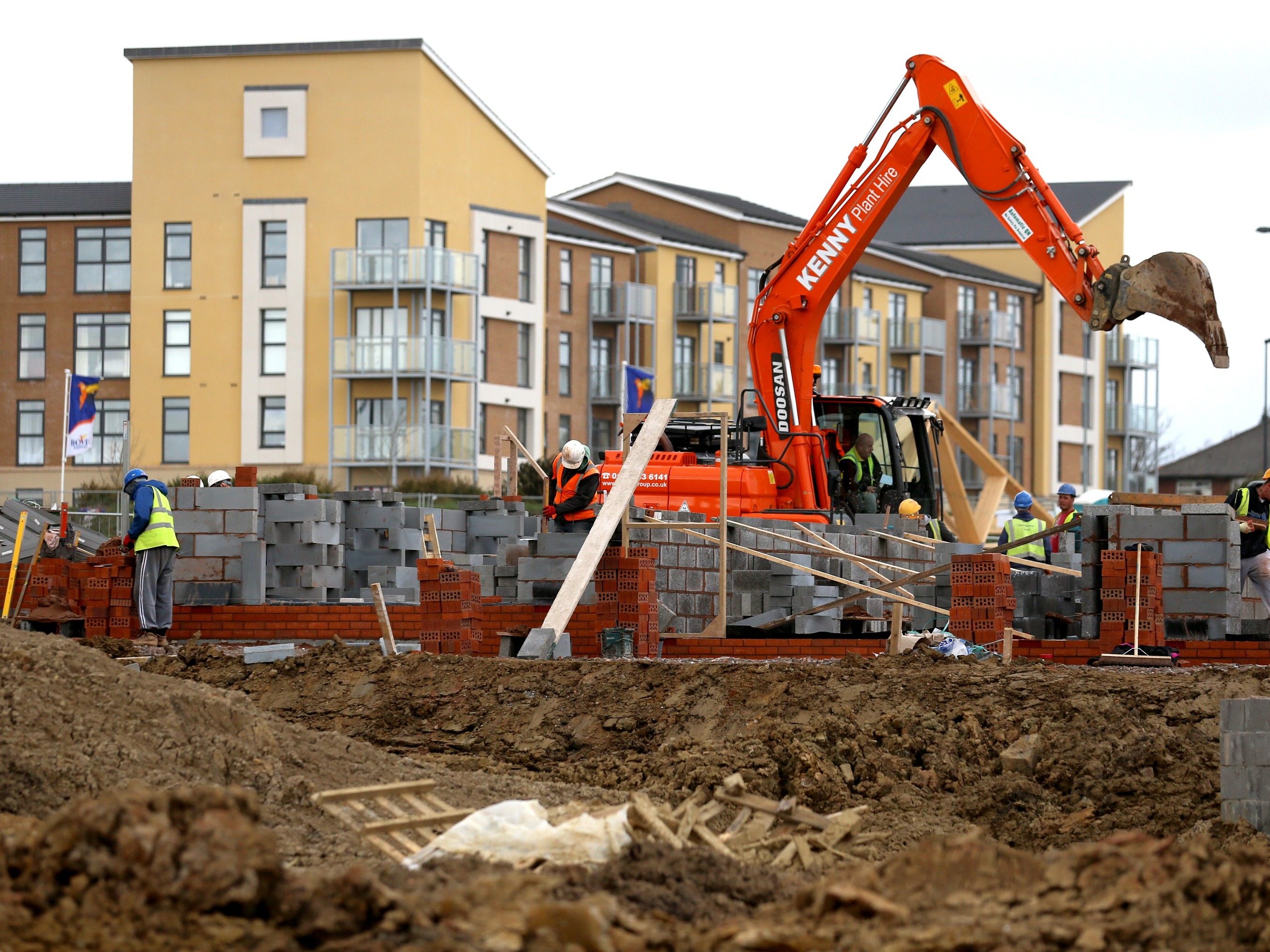 caption: Construction workers build new houses